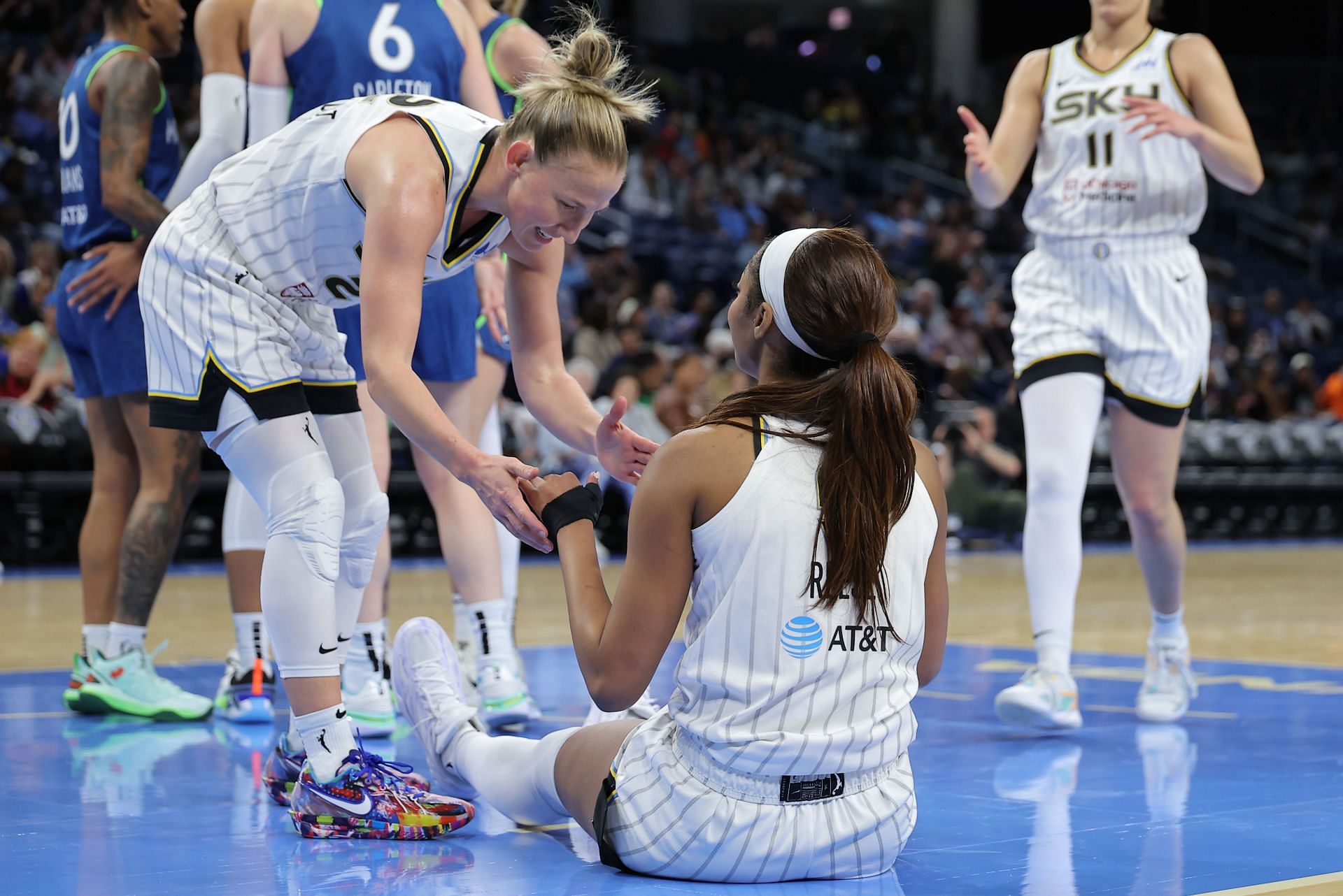 Courtney Vandersloot of the Chicago Sky helps Angel Reese - Source: Getty